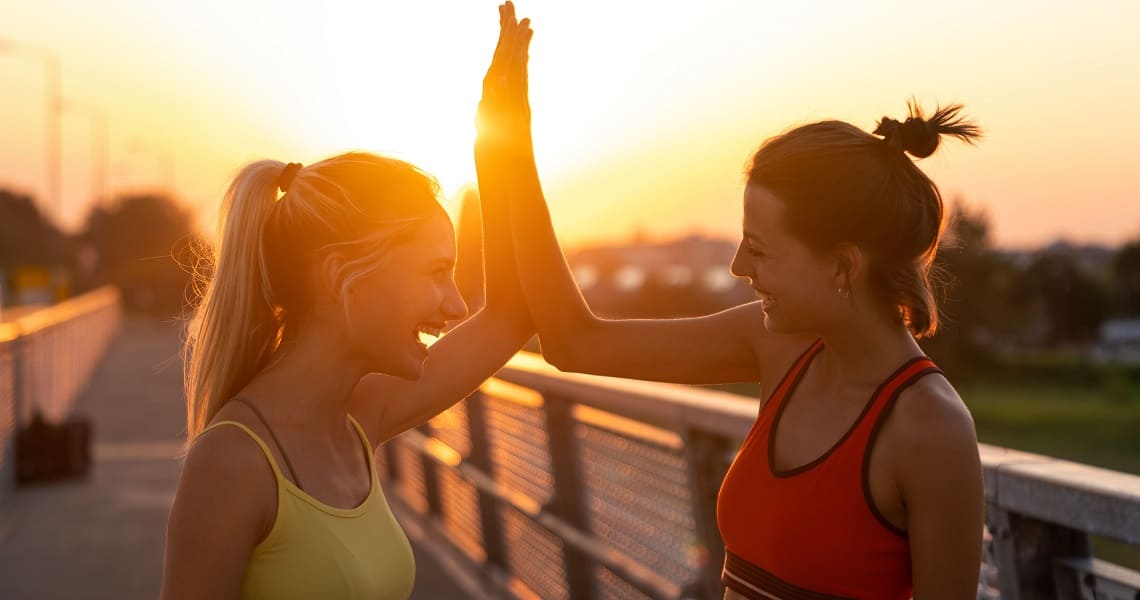 Zwei Frauen klatschen beim Sport ein