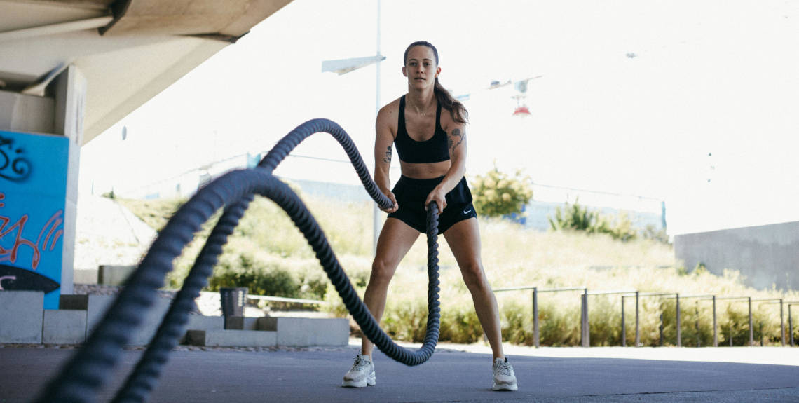 Frau trainiert mit Battel Ropes