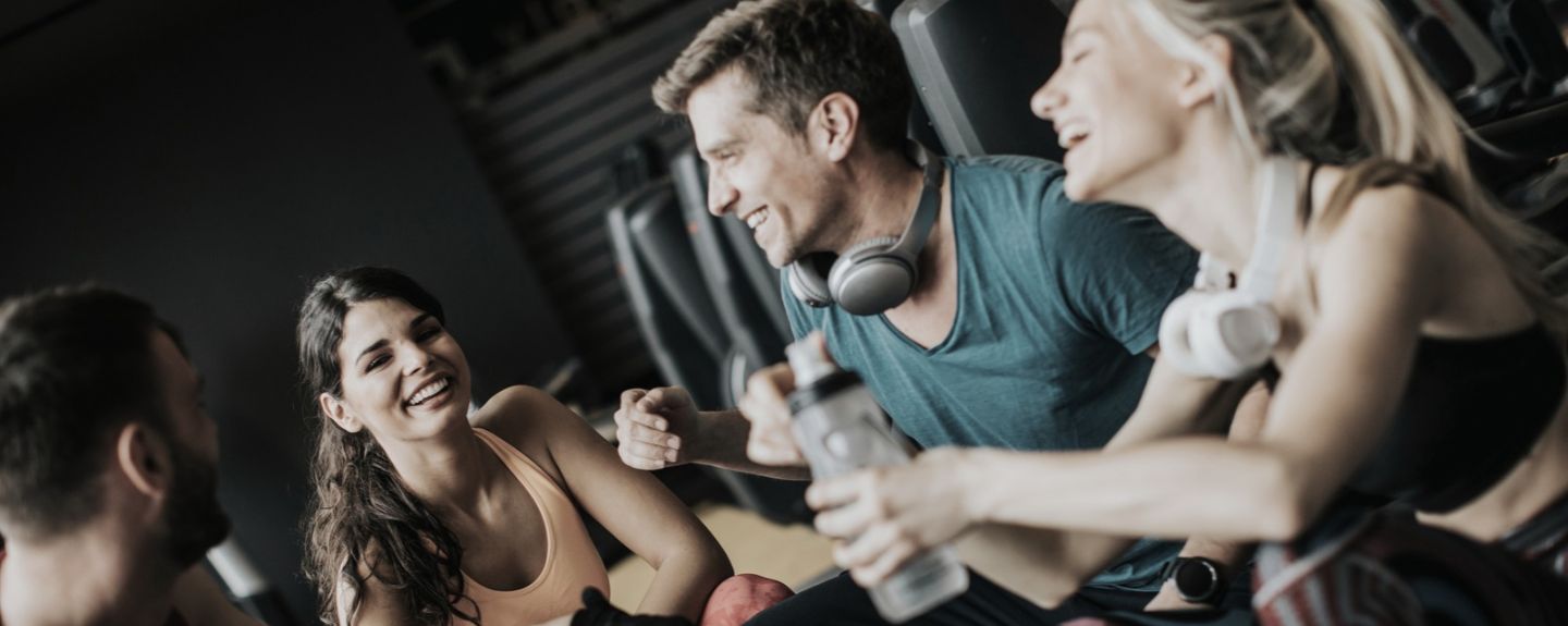 Gruppe sitzt zusammen im Fitnessstudio Gruppe sitzt zusammen im Fitnessstudio