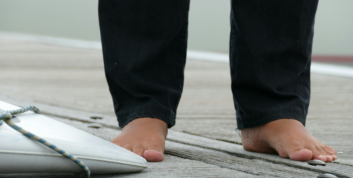 Foto von Füßen eines Mannes auf Holzsteg