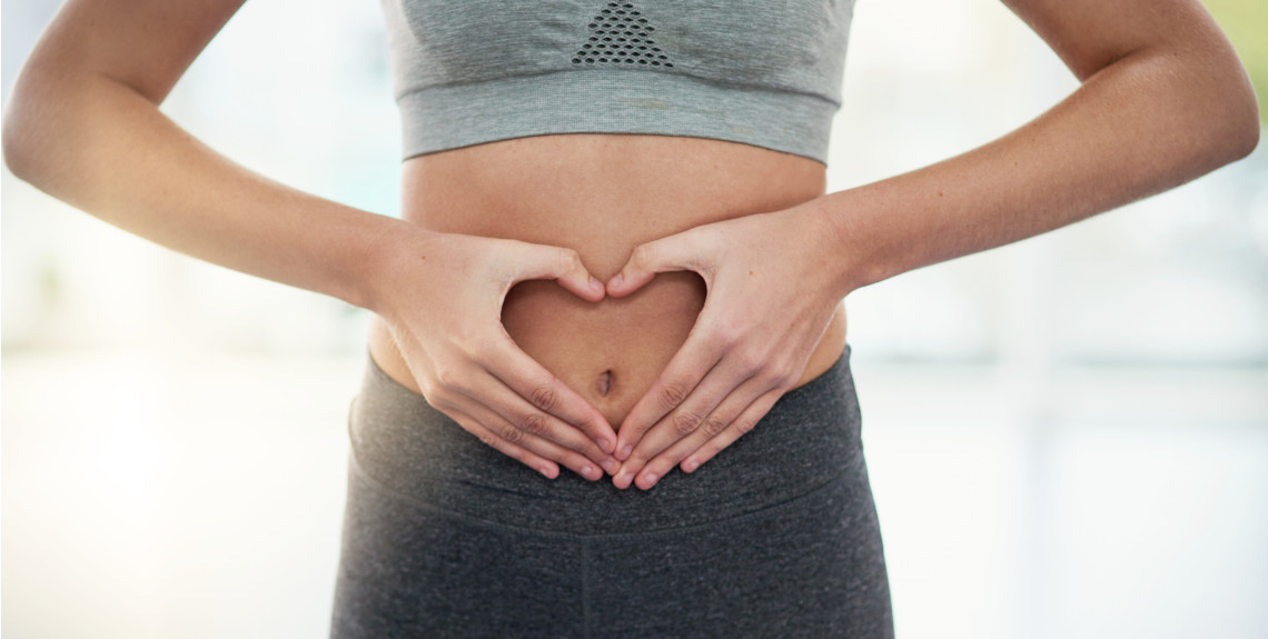 Frau hält Hände auf ihren Bauch