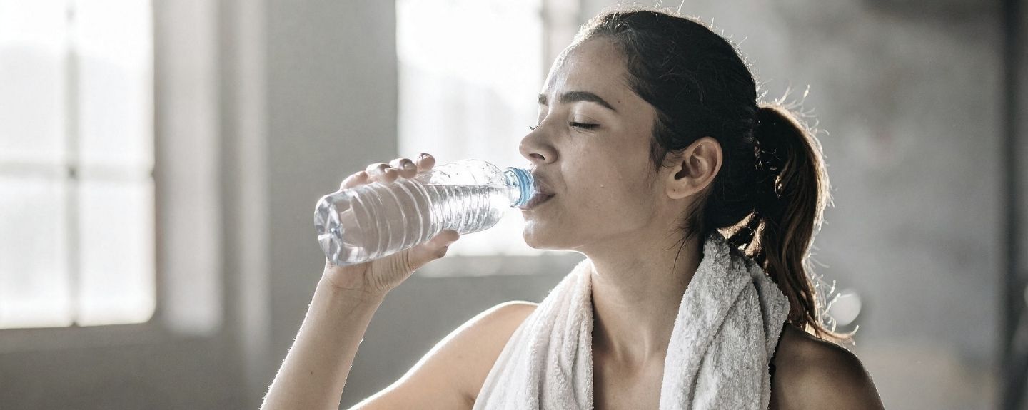 Frau trinkt aus einer Wasserflasche Frau trinkt aus einer Wasserflasche