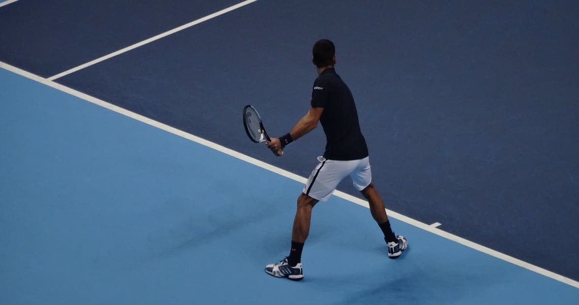 Mann spielt Tennis auf Tennisplatz