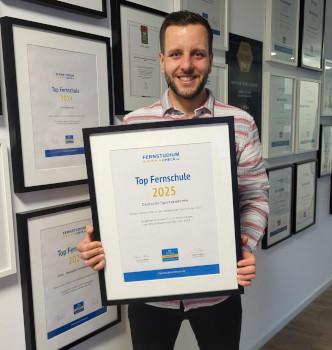 Mitarbeiter David hält die Top Fernschule Urkunde Mitarbeiter David hält die Top Fernschule Urkunde