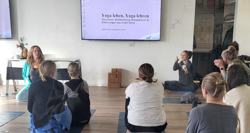 Die Teilnehmenden sitzen in einem Vortrag